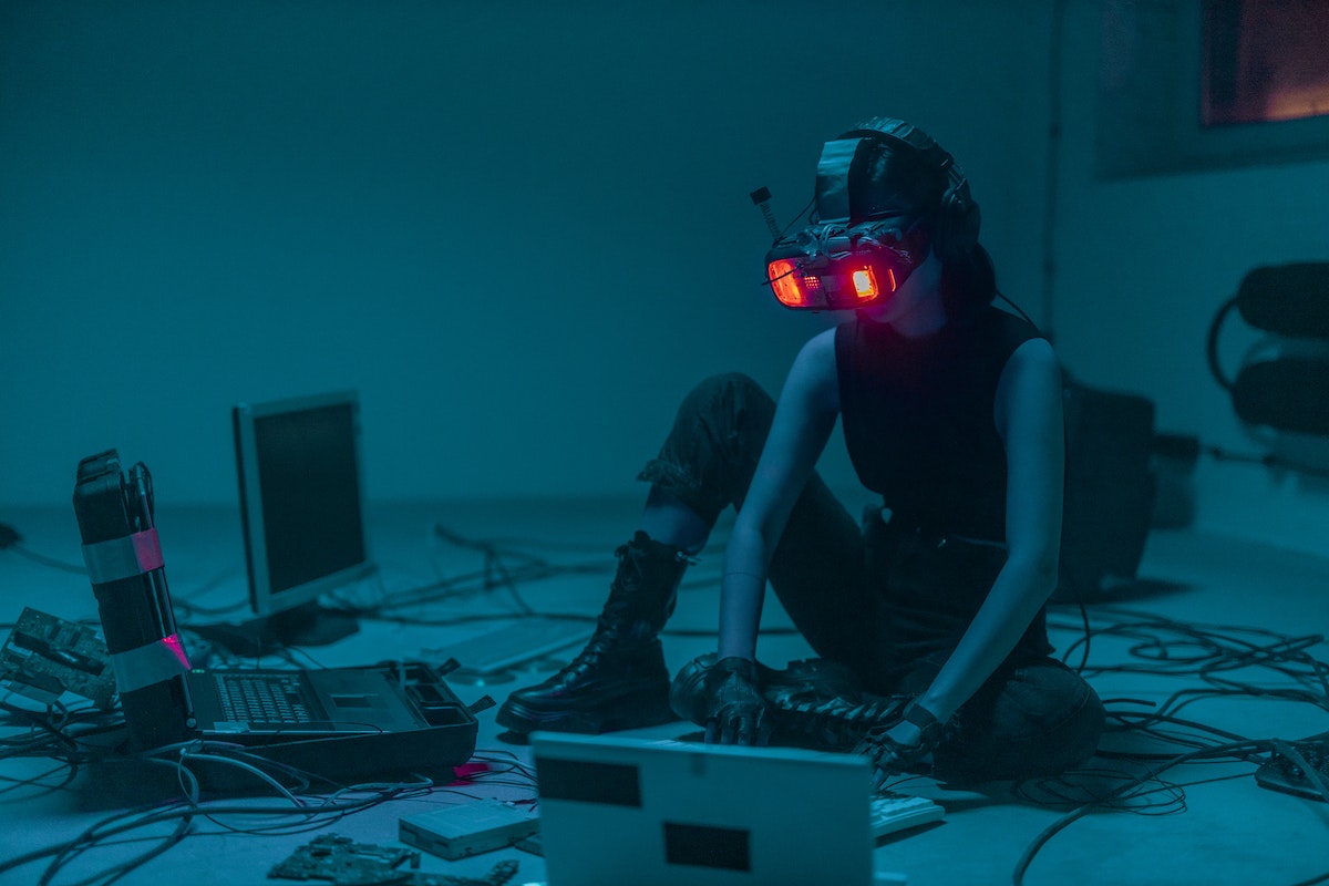 Jovem hacker com óculos do futuro mexendo em um computador 