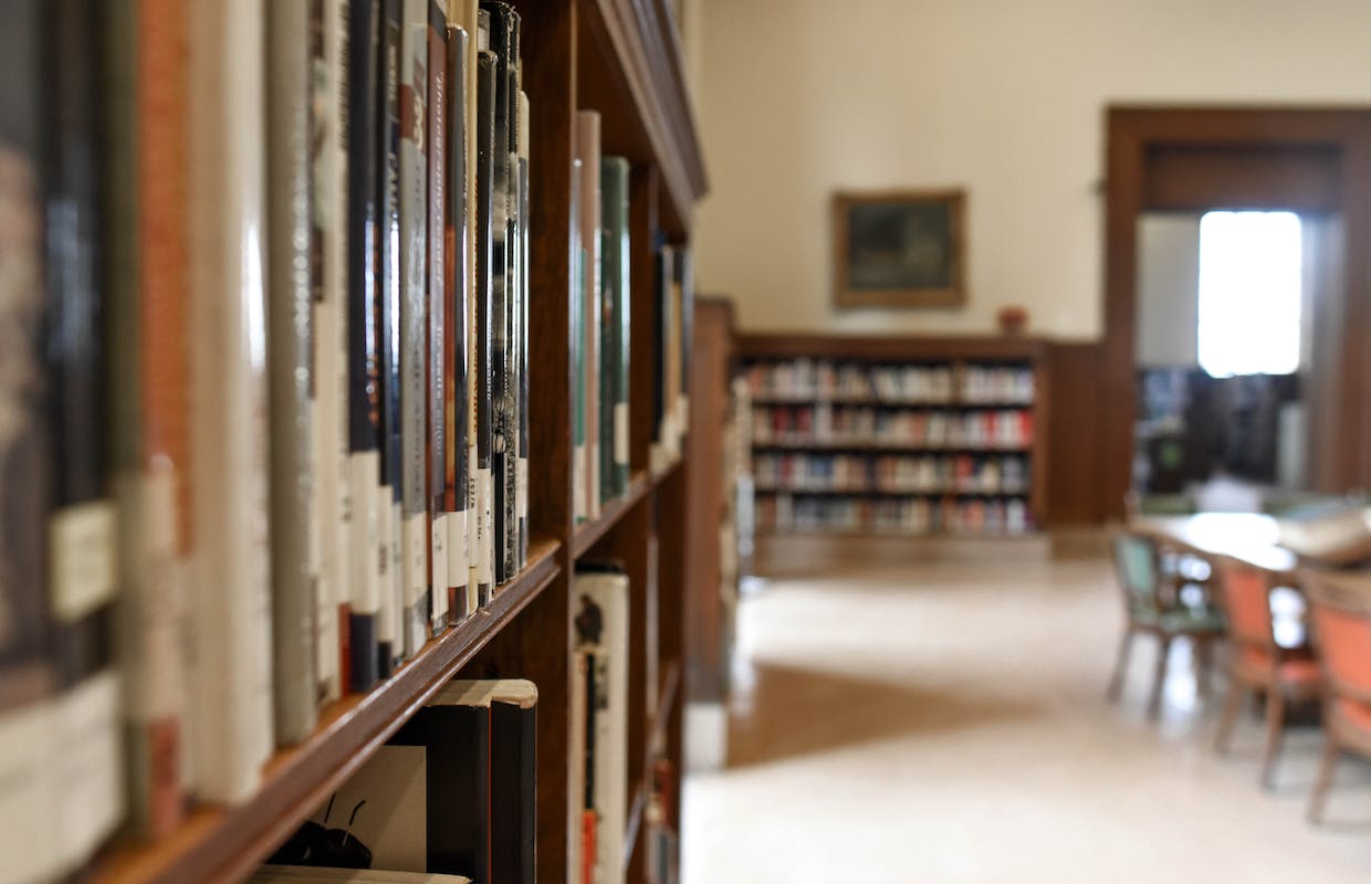 Uma foto de dentro da biblioteca ao lado das estantes de livros