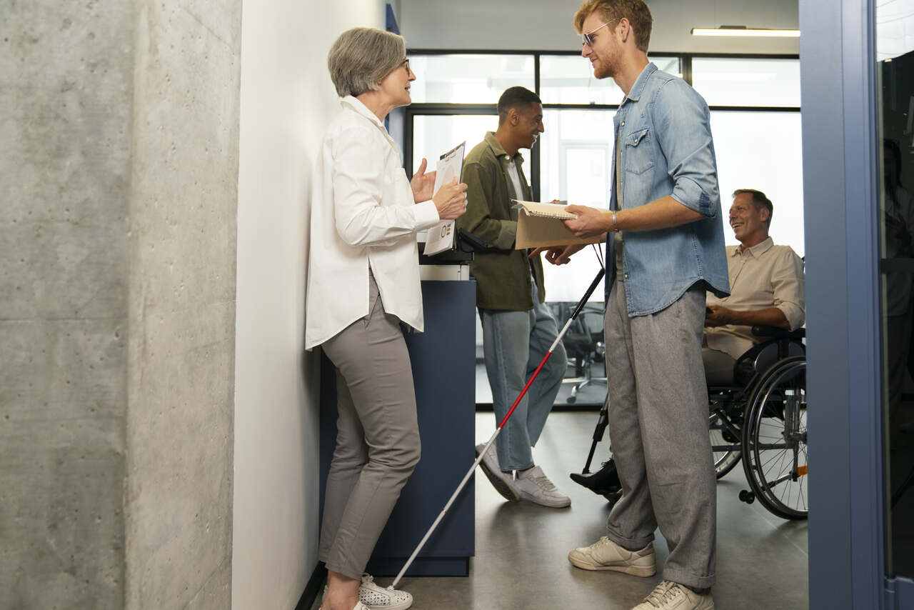 Deficiente visual fala sobre trabalho com colega no corredor do escritório 