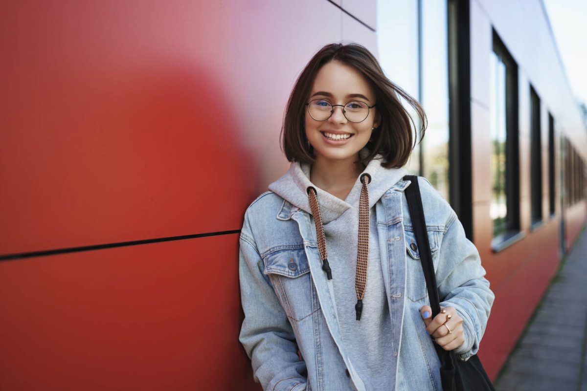 Jovem estudante posa sorridente 