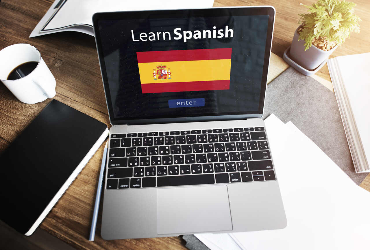 Close de notebook aberto em tela de curso de Espanhol 