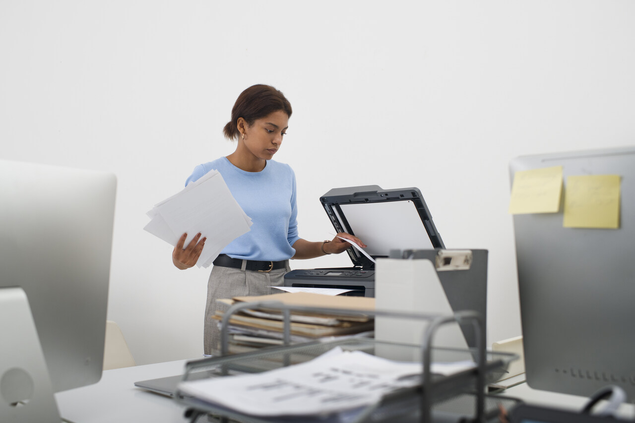 Jovem assistente administrativa tira fotocopias