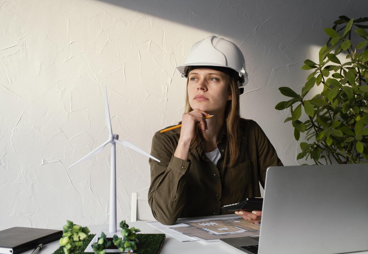 Profissional de geotecnologia pensativa diante seu notebook durante trabalho 