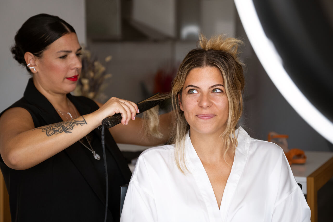 Cabelereira faz penteado em cabelo de cliente